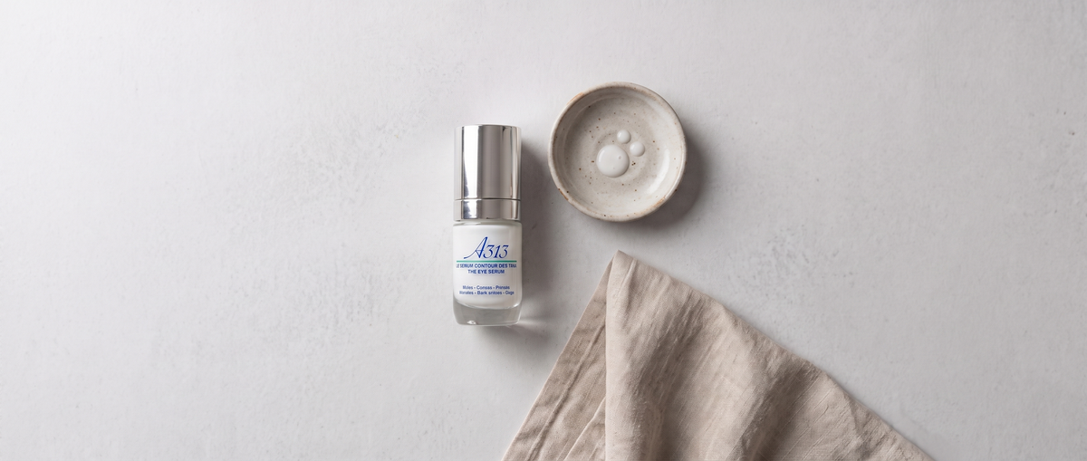 A313 Eye Serum flacon in een flatlay van bovenaf naast een schaaltje en gevouwen linnen doek